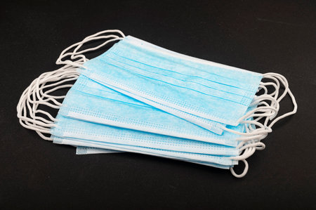 Medical disposable masks on a black background. Personal protective equipment. Close up