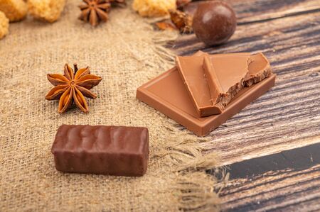 Chocolate and star anise on a background of rough homespun fabric. Close upの写真素材