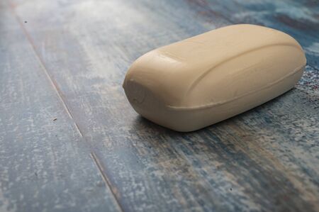 A piece of toilet soap on a wooden background. Close up. Clean hands prevention COVID-19の写真素材
