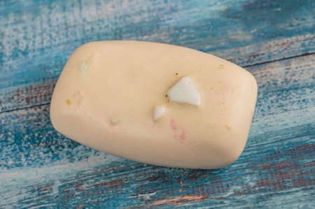 A piece of toilet soap on a wooden background. Close up. Clean hands prevention of COVID-19...