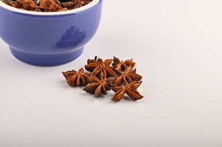 star anise in a blue ceramic spice mortar on a white background. Close upの写真素材