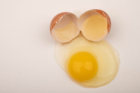 A broken chicken egg on a white background. Close up