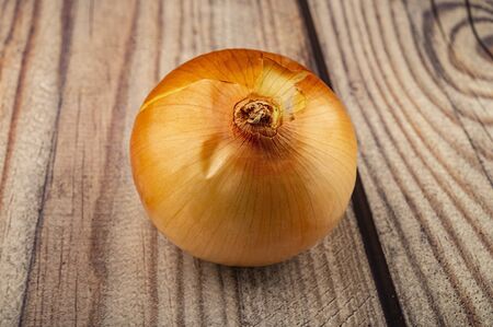 Juicy ripe onions on a wooden background. Close upの写真素材
