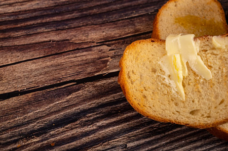 Fresh wheat toast with butter on a wooden background. Close up