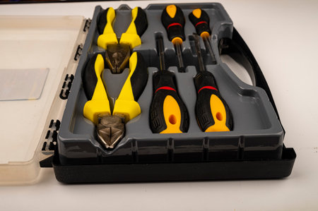 Various screwdrivers and pliers in a plastic case. Close up. Manual locksmith and installation tools...