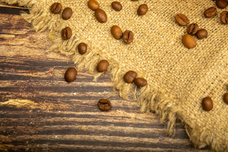 Coffee beans on a background of homespun fabric with a rough texture. Close up