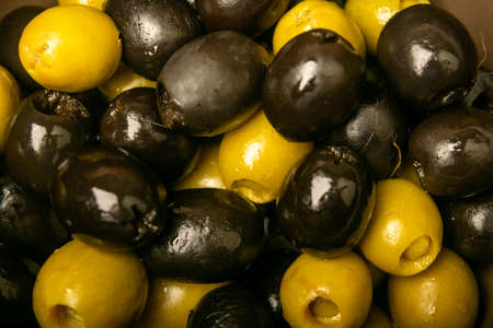 Green olives and black olives the texture of the surface. Close upの写真素材