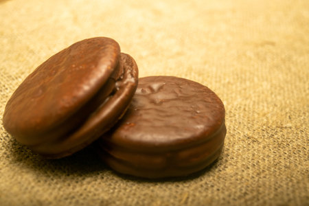 Cookies covered with chocolate on a background of homespun fabric with a rough texture. Close up