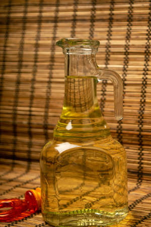 A bottle of olive oil on the background of a reed Mat. Close upの写真素材