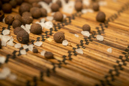 Fragrant black pepper and coarse sea salt in bulk on a reed Mat. Close upの写真素材