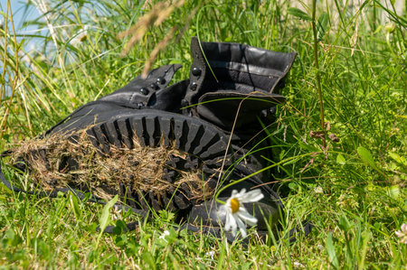Old leather Hiking boots in the green grass. Summer is a time of travel. Close up