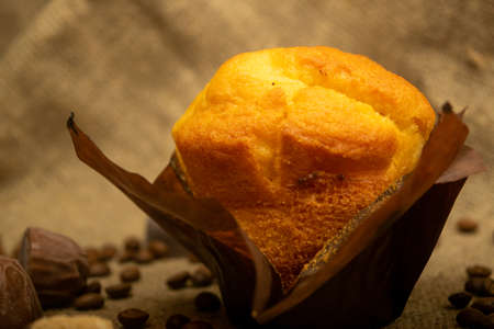 Fresh cupcake, coffee beans and chocolate on a homespun fabric with a rough texture. Close upの写真素材