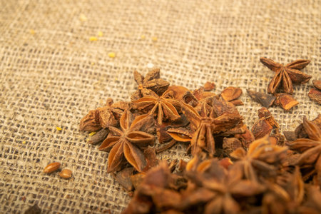A pile of star anise on a background of burlap with a rough texture surface texture. Close up