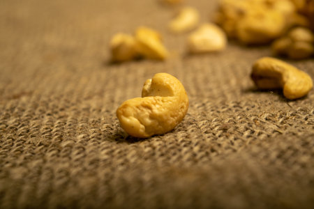 A pile of cashew nuts on burlap with a rough texture surface texture. Close up