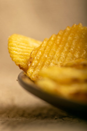 Fluted potato chips on a background of homespun fabric with a rough texture. Close up