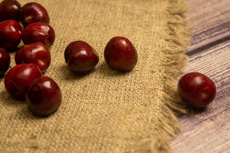 Ripe juicy cherries scattered on a homespun fabric with a rough texture. Close upの写真素材
