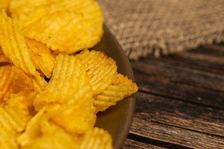 Fluted potato chips on a wooden background. Close up