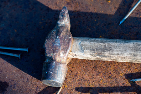 Old vintage hammer and nails on a rusty sheet of metal, close-up, selective focus