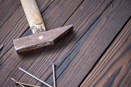 Old vintage hammer and nails on a wooden background, close-up, selective focus