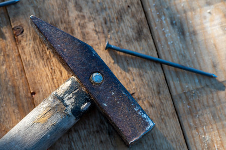 Old vintage hammer and nails on a wooden background, close-up, selective focus