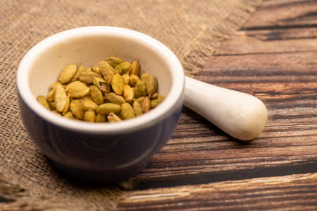 Cardamom in a ceramic mortar and pestle, close-up, selective focusの写真素材