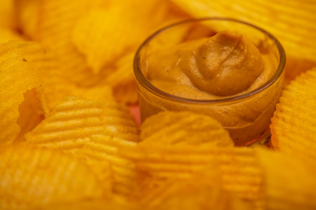 Crispy, delicious potato chips with mustard sauce. Close up