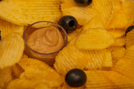 Crispy, delicious potato chips with mustard sauce and olives. Close upの写真素材