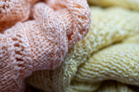Knitting needles, skeins of yarn and knitted fabric, home needlework. Close-up, selective focus