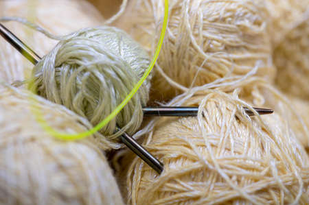 Knitting needles, skeins of yarn and knitted fabric, home needlework. Close-up, selective focusの写真素材