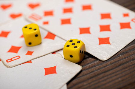 Playing cards and dice on a wooden table. Close-up, selective focus.