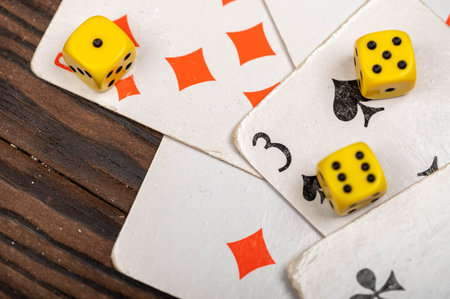 Playing cards and dice on a wooden table. Close-up, selective focus.