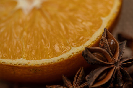 Half an orange and a star anise on a wooden table. Close-up, selective focus.