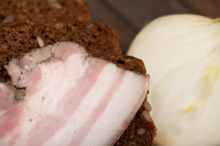 Sandwich with smoked brisket sliced on grain bread on a wooden cutting board. Close-up, selective focus.の写真素材