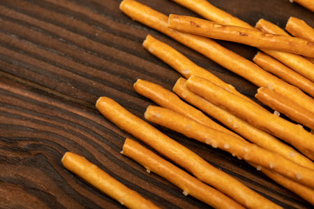 Salted bread strips scattered on a wooden table. Close-up, selective focus.の写真素材