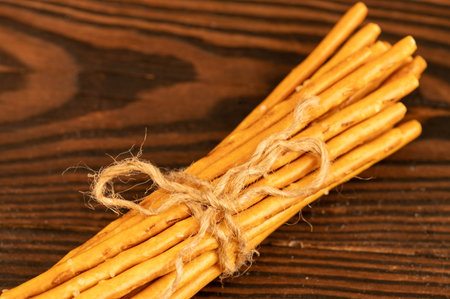 Salted breadsticks and salted pretzels scattered on the table. Close-up selective focus.
