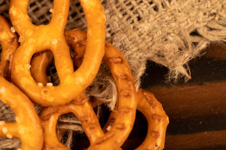 Salted breadsticks and salted pretzels scattered on the table. Close-up selective focus.の写真素材