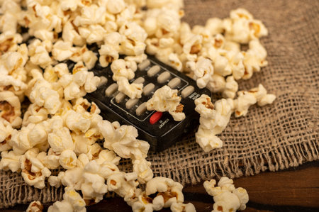 Popcorn scattered on the table and a remote control from the TV. Self-isolation in the covid-19...