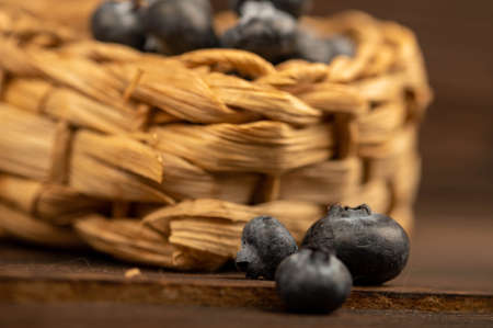 Fresh blueberries in a wicker basket on a wooden table. Harvest, village breakfast. Close-up selective focus.の写真素材
