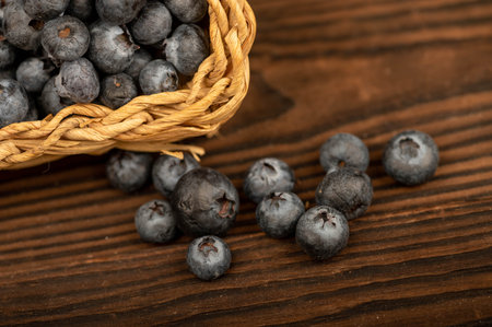 Fresh blueberries in a wicker basket on a wooden table. Harvest, village breakfast. Close-up...