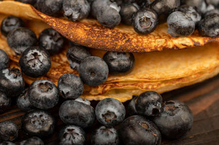 Fresh blueberries and traditional Russian pancakes. Shrovetide week of the end of winter. Close-up selective focus.の写真素材
