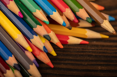 Colored pencils on a wooden table. Close-up, selective focus. Self-development during self-isolation...