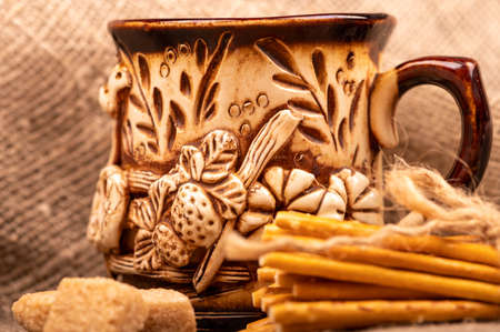Breadsticks with salt tied with string and an earthenware mug for tea. Close-up Selective focusの写真素材
