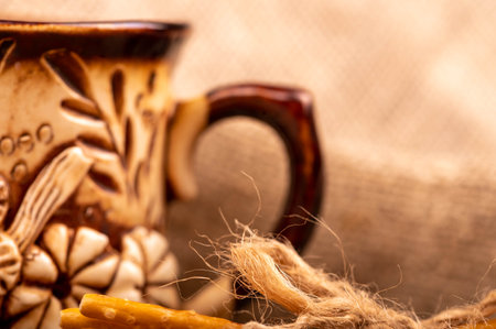 Breadsticks with salt tied with string and an earthenware mug for tea. Close-up Selective focusの写真素材