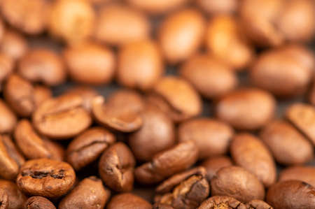 Roasted coffee beans scattered on the surface close-up, selective focusの写真素材