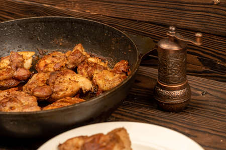 Fried pieces of meat in a frying pan, close-up, selective focusの写真素材