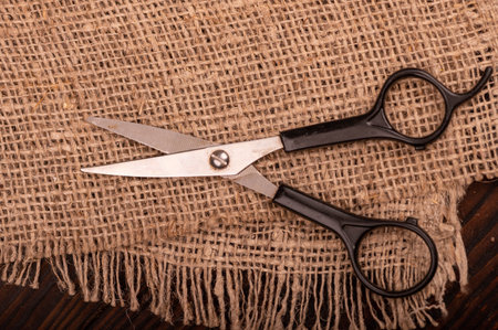 Small scissors on a piece of homespun fabric with a rough texture