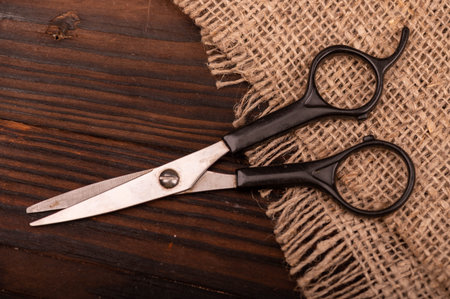 Small scissors on a piece of homespun fabric with a rough texture