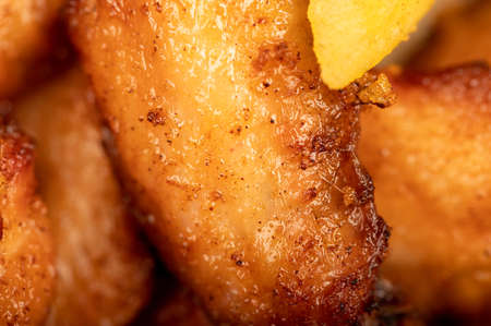 Fried chicken wings and French fries on a plate, close-up, selective focusの写真素材