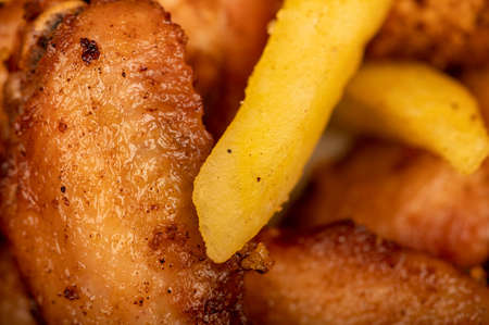 Fried chicken wings and French fries on a plate, close-up, selective focusの写真素材