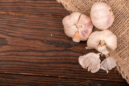 Heads of young garlic on a table covered with burlap, close-up, selective focusの写真素材